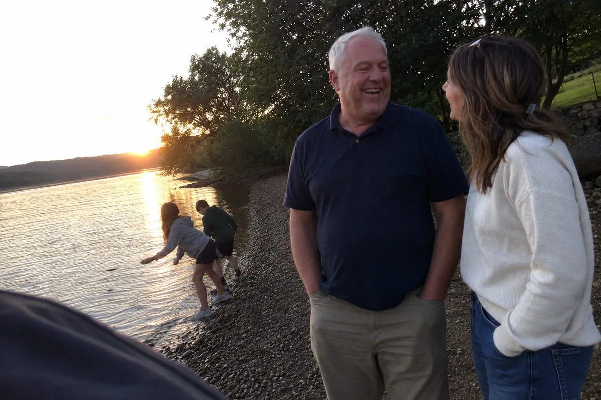 Ray Delgado, 58, at a lake shoreline with his daughter and grandkids at golden hour